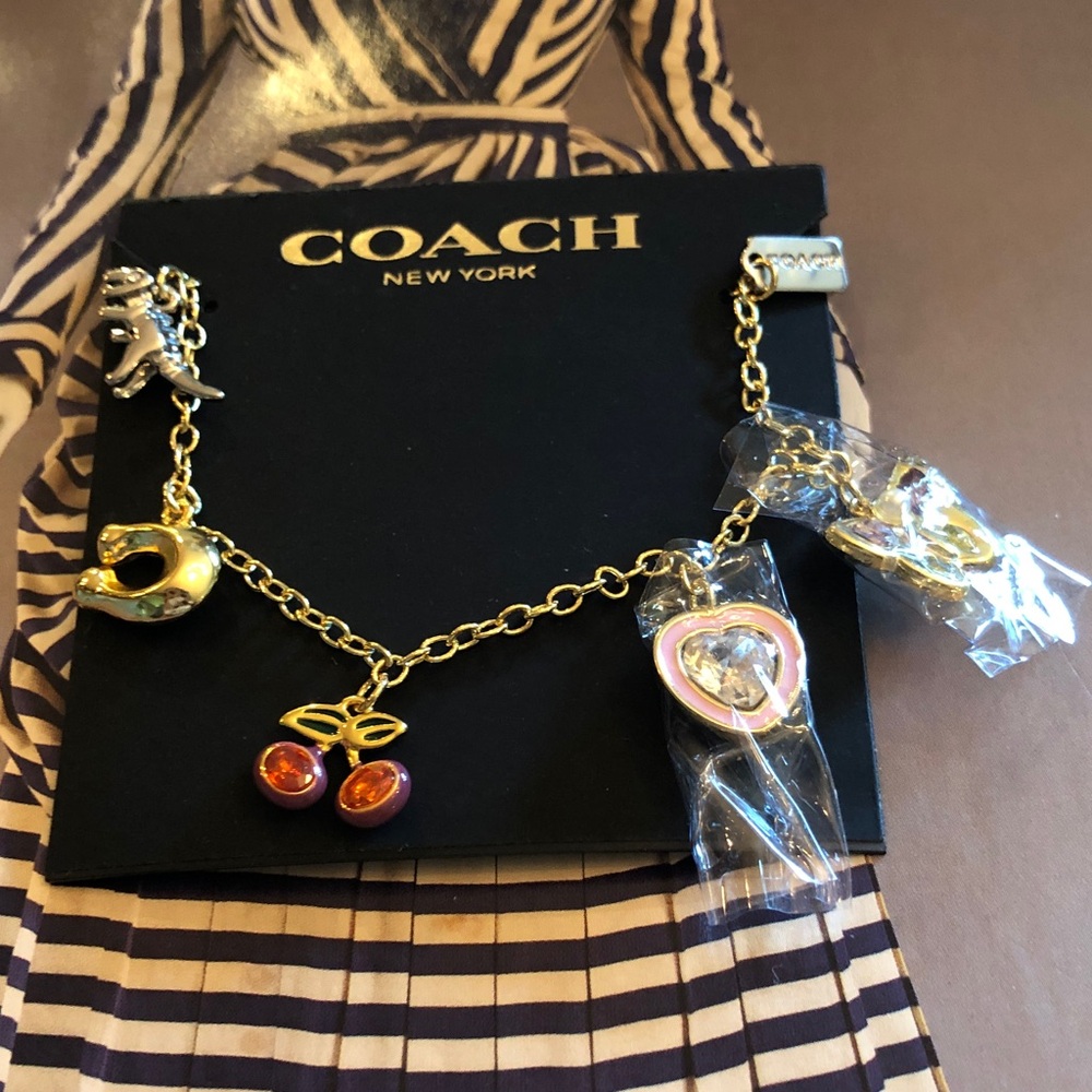 Authentic New on card. Coach Gold-Tone Charm bracelet with charms.